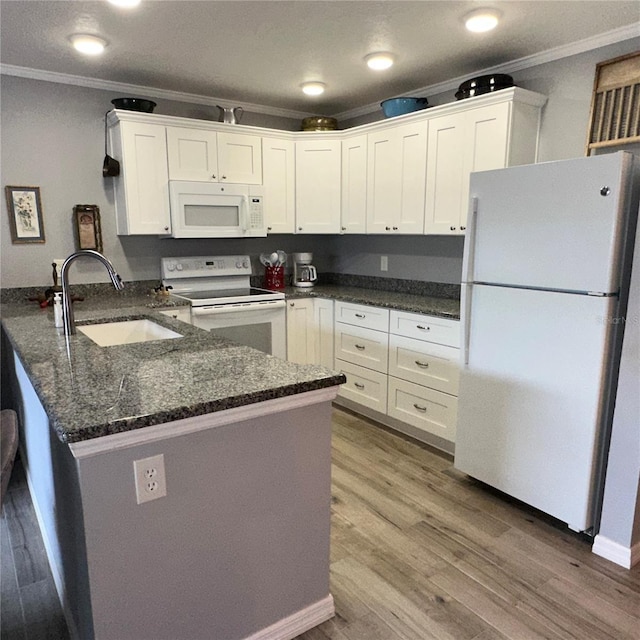 kitchen with sink, white cabinets, white appliances, and kitchen peninsula