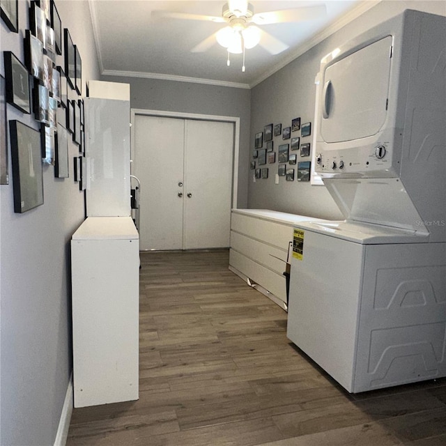 clothes washing area with ornamental molding, stacked washer / drying machine, ceiling fan, and dark hardwood / wood-style floors