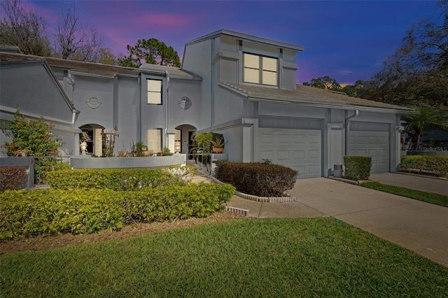 view of front of property with a garage, driveway, and stucco siding