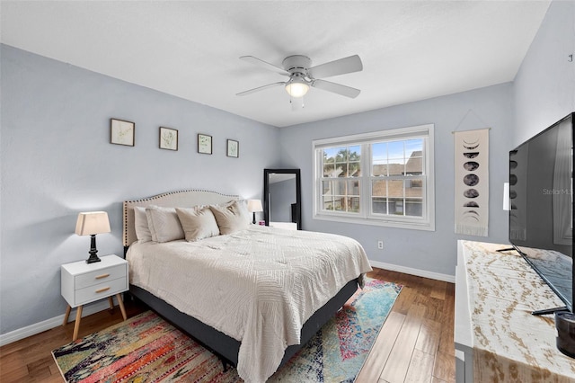 bedroom with a ceiling fan, baseboards, and wood finished floors