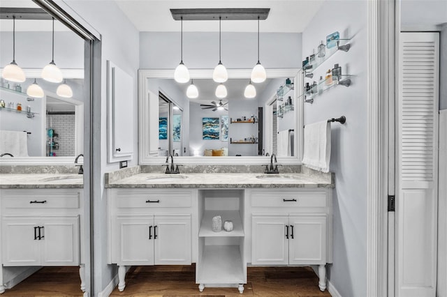 bathroom featuring double vanity, a sink, and wood finished floors