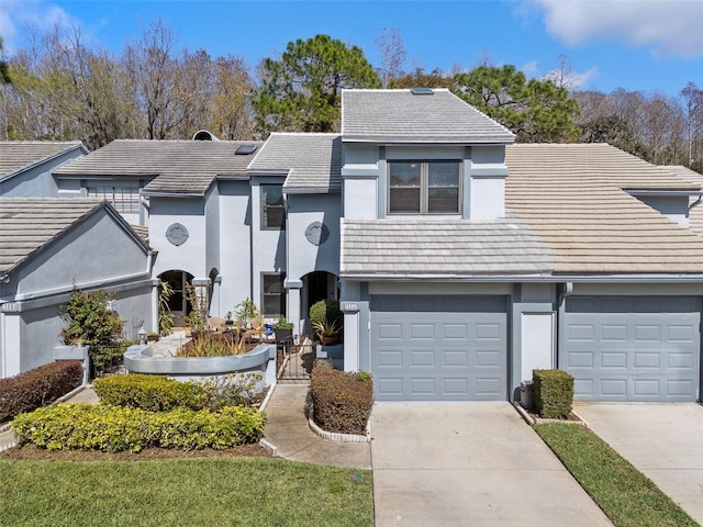 view of front facade featuring driveway, an attached garage, and stucco siding