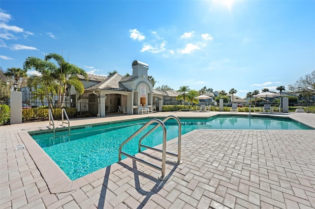 community pool featuring fence and a patio