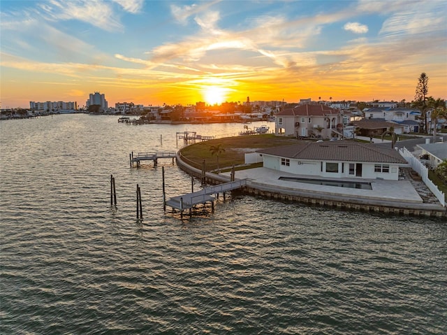 dock area with a water view, fence, and a patio