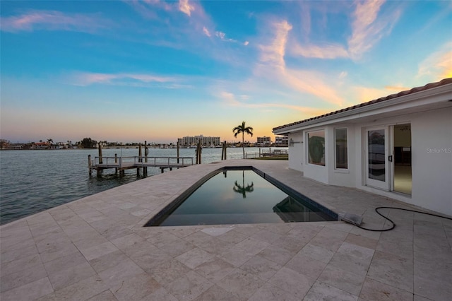 dock area featuring a water view, an outdoor pool, and a patio