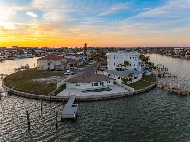 aerial view at dusk featuring a water view