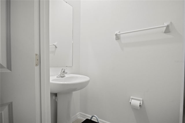 bathroom featuring baseboards and a sink