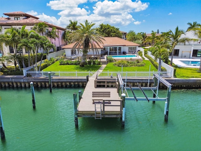 dock area with a water view, a yard, and a fenced backyard