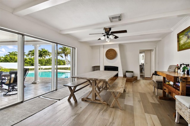 dining room with beam ceiling, visible vents, and light wood finished floors