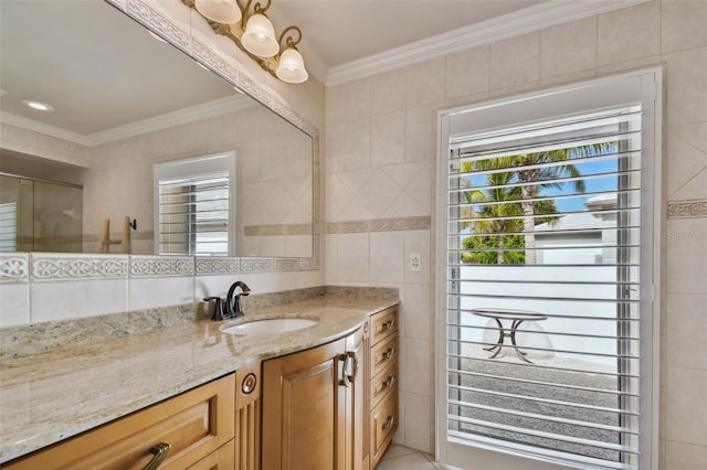 bathroom featuring ornamental molding, vanity, and tile walls