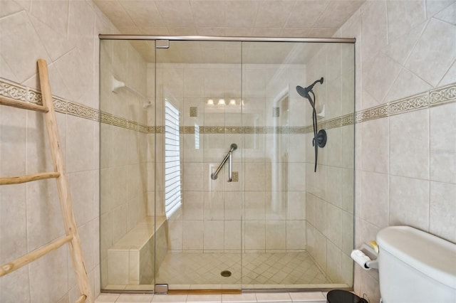 full bath featuring a stall shower, tile walls, and toilet