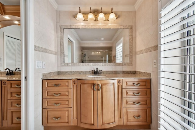 full bathroom with vanity, ornamental molding, a shower stall, and tile walls