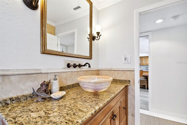 bathroom featuring ornamental molding, vanity, and visible vents