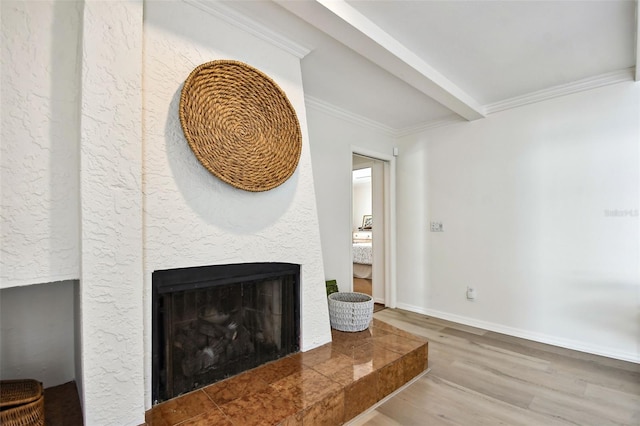 living room with wood finished floors, a multi sided fireplace, baseboards, beam ceiling, and crown molding