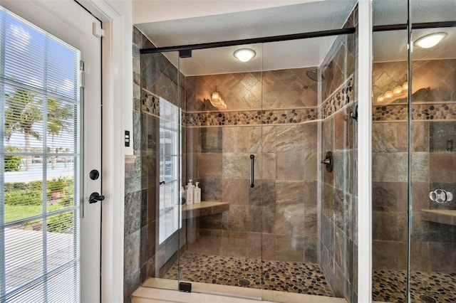 full bathroom with a stall shower and a textured ceiling