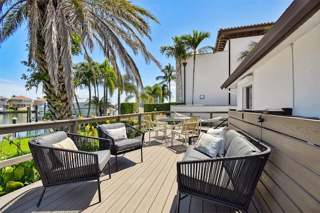 deck featuring a water view and an outdoor living space