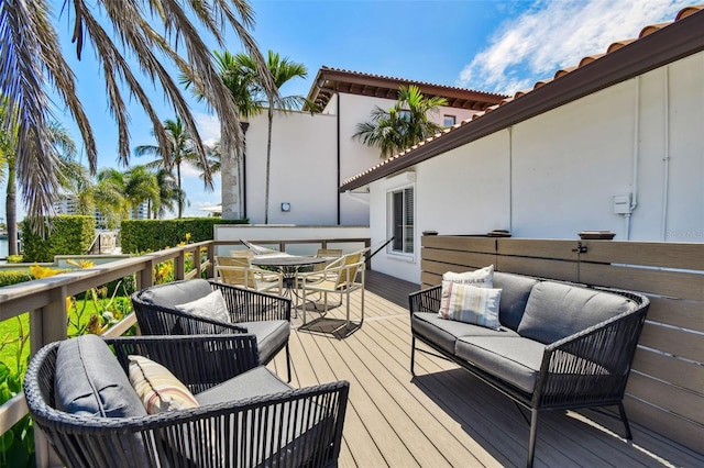 wooden deck with outdoor dining space and outdoor lounge area