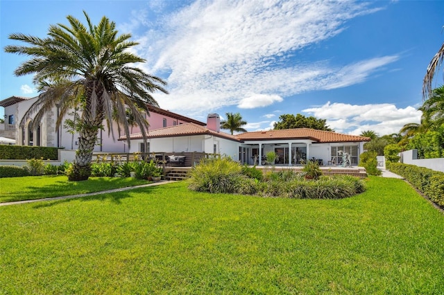 rear view of house featuring a yard and fence