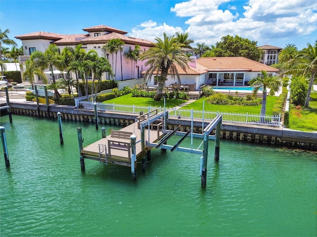 dock area with a lawn, a water view, a fenced backyard, and an outdoor pool