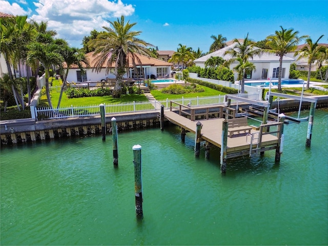 view of dock featuring a yard, a fenced backyard, a water view, and boat lift