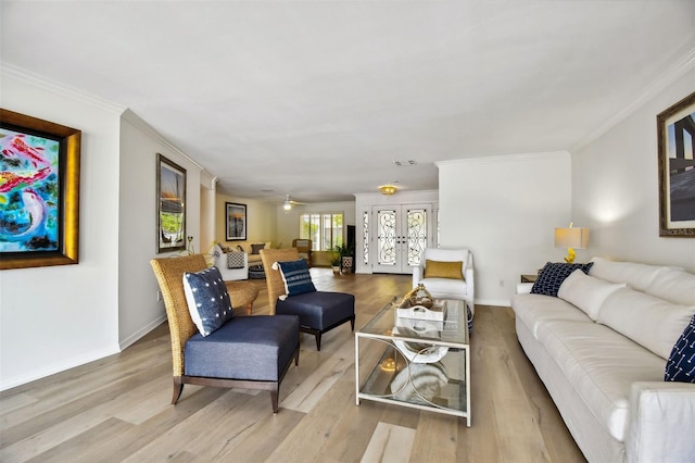 living room with visible vents, baseboards, ornamental molding, french doors, and light wood finished floors