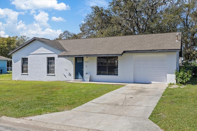 ranch-style house with an attached garage, a shingled roof, a front lawn, and concrete driveway