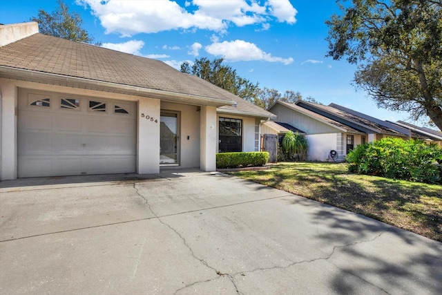 ranch-style home with a garage and a front yard