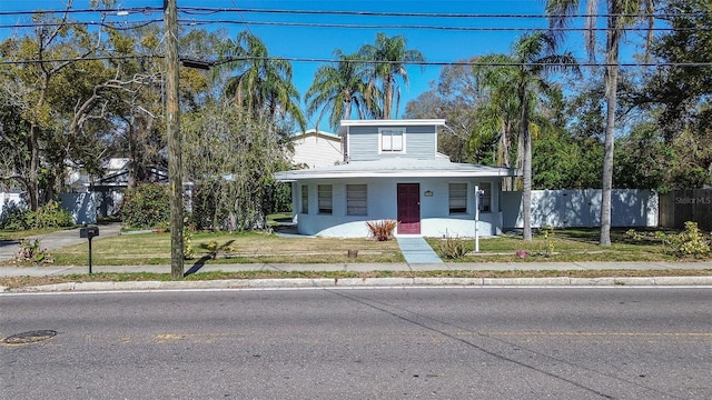 bungalow-style home featuring a front yard, fence, and stucco siding