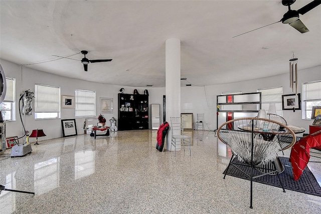 interior space with speckled floor and a ceiling fan