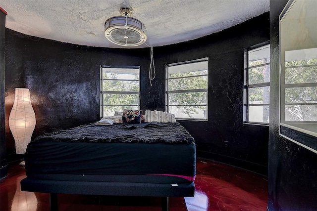 bedroom featuring a textured ceiling and a textured wall