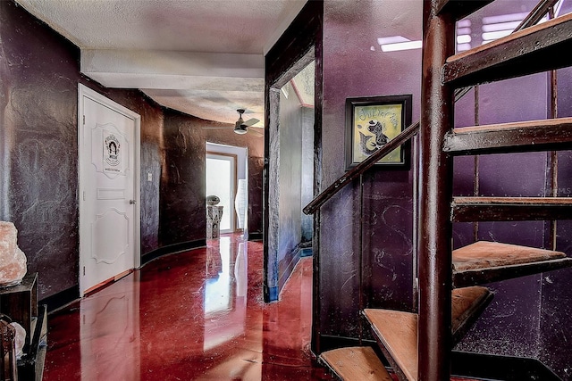 interior space featuring a textured ceiling and baseboards