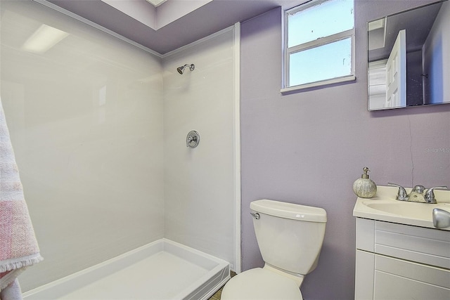 bathroom with toilet, a shower stall, and vanity