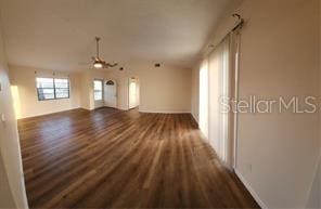 unfurnished living room featuring lofted ceiling and dark wood finished floors