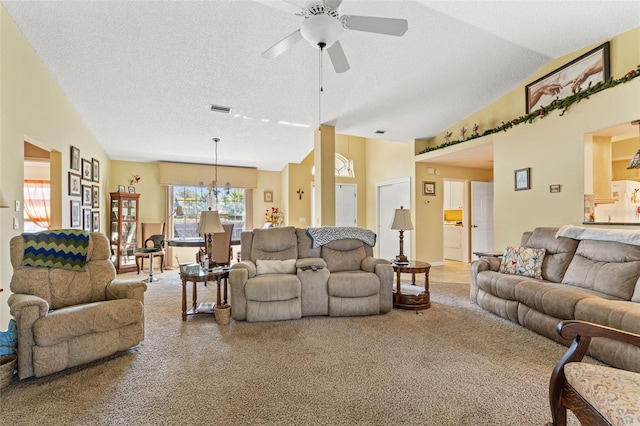 living room with lofted ceiling, ceiling fan, carpet floors, and a textured ceiling