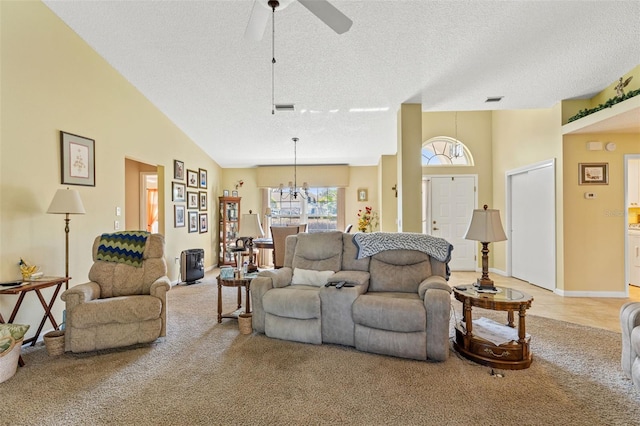 living room with light carpet, ceiling fan with notable chandelier, high vaulted ceiling, and a textured ceiling