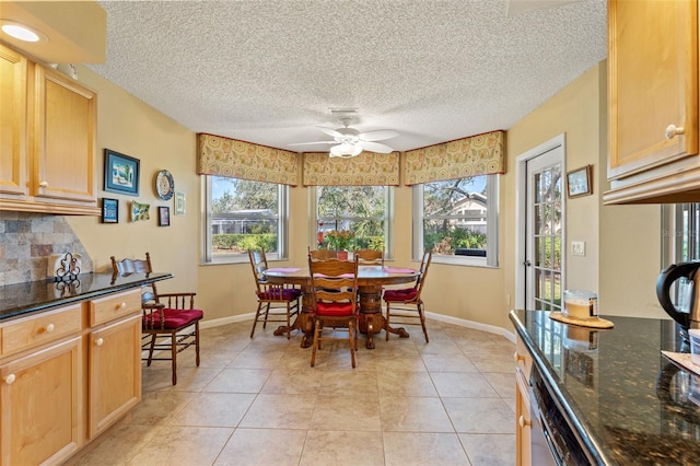 dining space featuring light tile patterned floors, a textured ceiling, and ceiling fan