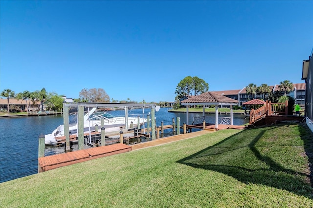 dock area with a water view, boat lift, and a lawn