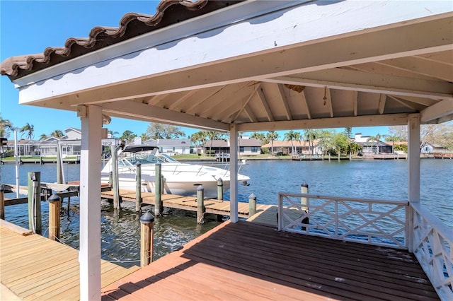 view of dock with a residential view and a water view