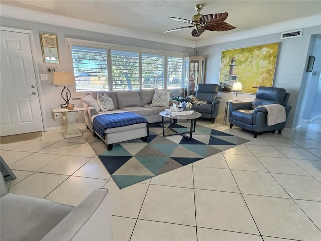 living room with light tile patterned floors, visible vents, baseboards, a ceiling fan, and a tray ceiling