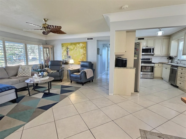 living room with light tile patterned floors, visible vents, and ceiling fan