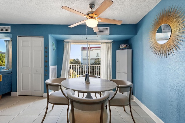 tiled dining area featuring ceiling fan, a healthy amount of sunlight, and a textured ceiling