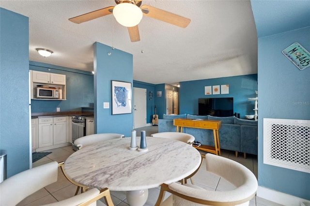 tiled dining area with a textured ceiling