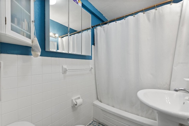 bathroom with sink, tile walls, and toilet