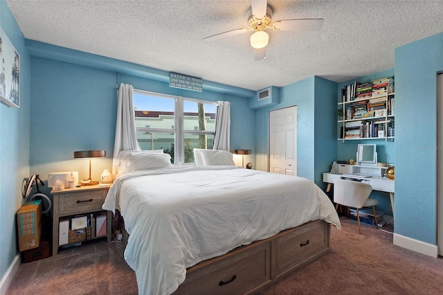 carpeted bedroom with ceiling fan, a closet, and a textured ceiling