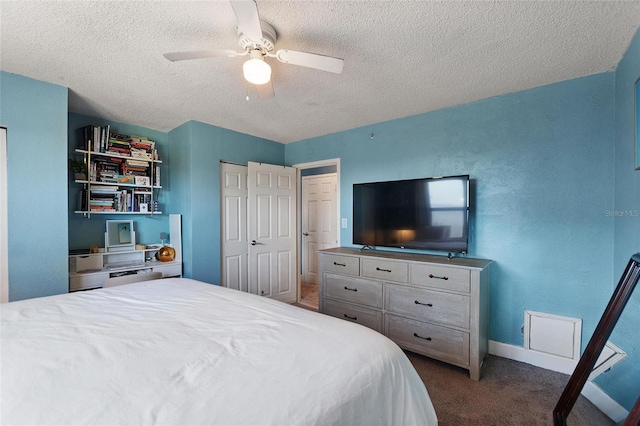 bedroom with ceiling fan, a closet, a textured ceiling, and dark colored carpet