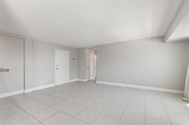 3315 58th Ave S Unit 314, Saint Petersburg, FL 33712 - unfurnished room with a textured ceiling, light tile patterned floors, and baseboards