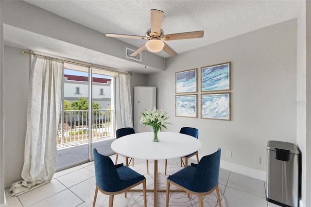 3315 58th Ave S Unit 314, Saint Petersburg, FL 33712 - dining room with light tile patterned floors, ceiling fan, a textured ceiling, and baseboards
