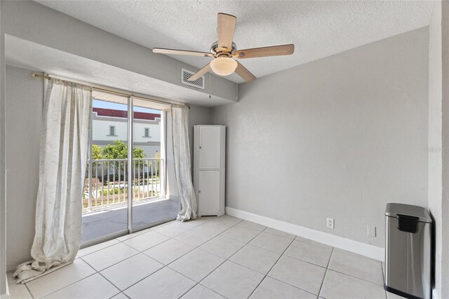 3315 58th Ave S Unit 314, Saint Petersburg, FL 33712 - empty room with a textured ceiling, a ceiling fan, baseboards, and light tile patterned floors
