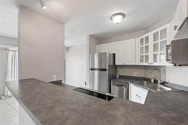 3315 58th Ave S Unit 314, Saint Petersburg, FL 33712 - kitchen featuring stainless steel appliances, a sink, dark countertops, glass insert cabinets, and a peninsula