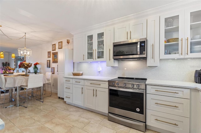 kitchen featuring stainless steel appliances, hanging light fixtures, decorative backsplash, and white cabinets